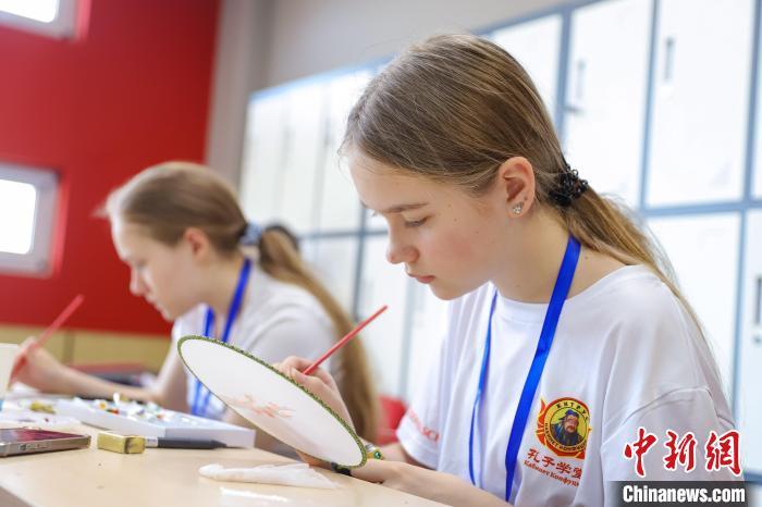 8月12日,俄罗斯学生体验手绘团扇。当日,12名俄罗斯学生走进位于山东省青岛市李沧区的恒星科技学院,通过体验剪纸、手绘京剧脸谱和团扇,近距离感受中华传统文化的魅力。张鹰 摄