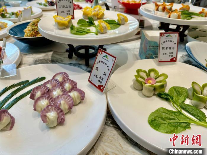 玫瑰之约、国色天香、鸟语花香……在甘肃省金昌市，一家饭店推出了一款“七彩饺子宴”，与以往吃的白面包成的饺子不同，这些饺子是用赤橙黄绿青蓝紫七种颜色的面团打造而成，这七种色彩都是从植物、蔬菜、水果、花卉中提炼出来。“多巴胺”配色的饺子既具观赏价值，又能让食客享受不同馅料的饺子带来的食趣。 图为“七彩饺子宴”中花型摆盘各不相同的饺子。王牧雨 摄