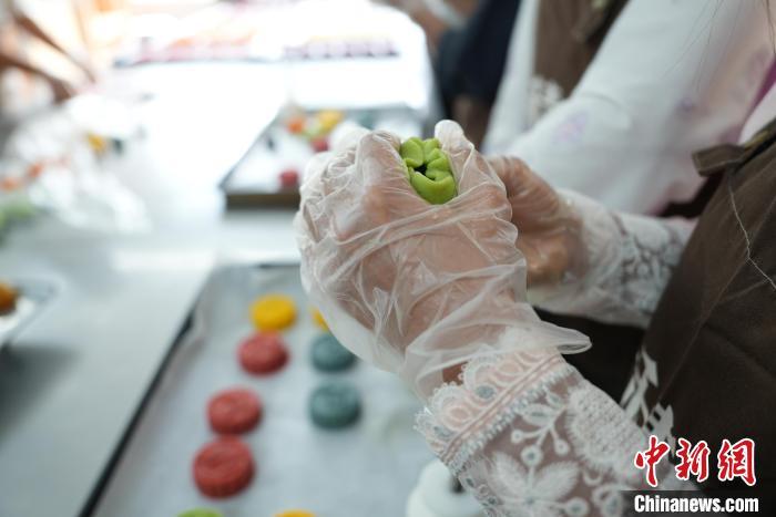 中秋节将至,9月3日,在河北省邯郸市丛台区的一家点心铺内,几位就读于河北工程大学的外国留学生,在面点师傅指导下,经过压膜、包馅、塑形等流程,印有《胡服骑射》《黄粱美梦》《邯郸学步》等成语的月饼制作完成。成语月饼是一种结合邯郸成语典故与月饼文化的创意产品,通过在月饼上刻印成语故事,不仅丰富了月饼的文化内涵,也让人们在品尝美食的同时,感受到邯郸深厚的历史文化。图为9月3日,留学生正在包月饼馅。董业冉 摄