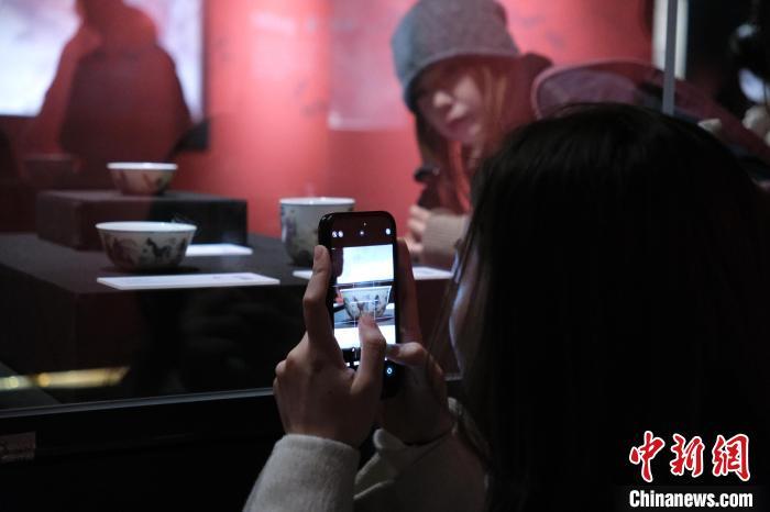 1月7日，浙江杭州，探馆观众在清雍正斗彩鸡缸杯前拍照留念。