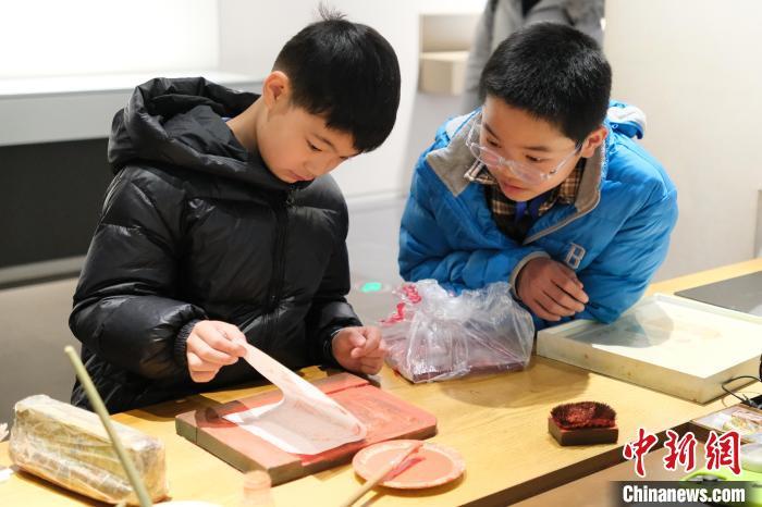 2月7日,浙江杭州,小朋友在体验木版水印技艺。春节期间,浙江省非物质文化遗产馆成为家庭出游的热门之选,民众在传统技艺体验中感受年味。中新社记者 曹丹 摄