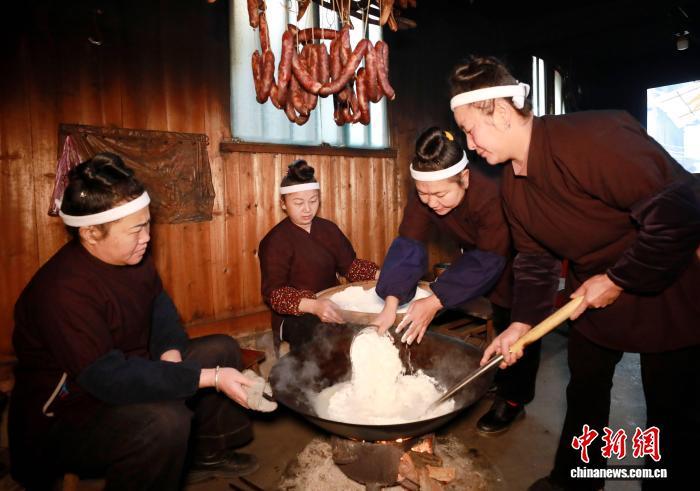 2月9日,在广西三江侗族自治县良口乡和里村欧阳屯,吊脚木楼内洋溢着浓浓年味,侗族妇女们结伴围炉,用传统工艺手工制作油果,以独特年俗迎接新春到来。油果是侗族打油茶的主要佐料之一,以优质糯米为原料,经舂粉、和面、切丁后,用本地特产的野生山茶油炸制而成。在侗乡,春节前炸油果、打油茶不仅是一种饮食习俗,更蕴含着人们对新的一年生活红火、甜蜜圆满的美好期盼。图为侗族妇女在制作油果。龚普康 摄