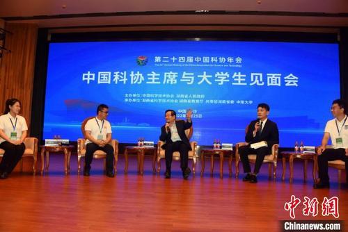 全国政协副主席、中国科协主席万钢（中）与大学生代表交流。　中新社记者  孙自法　摄