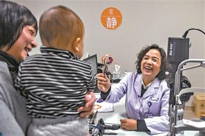 为小患者检查前，陈伟蓉教授先用玩具逗乐对方。（图片来源：大洋网 廖雪明/摄）