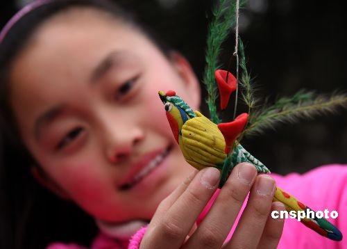 当天山东枣庄市人民公园内一位民间艺人制作的各种面塑鸟儿栩栩如生