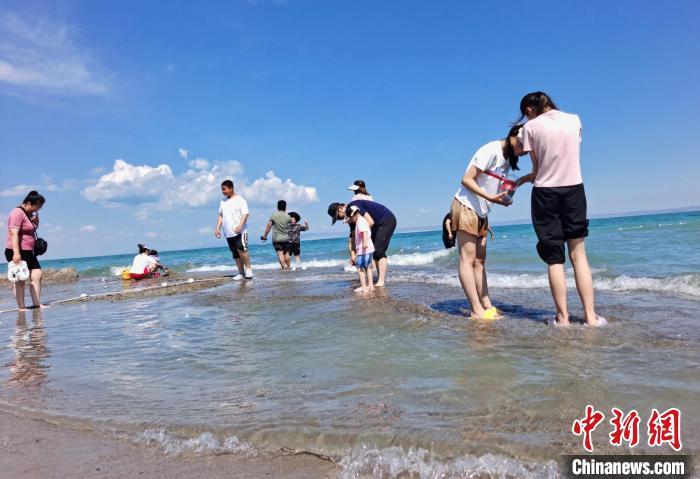 中国侨网6月17日至19日古尔邦节假期期间，新疆旅游市场火热。据了解，喀纳斯、赛里木湖、巴音布鲁克、江布拉克等知名景区游客接待量创今年历史新高。其中，阿勒泰地区多个景区实行限流措施，游客须提前订票才能进入。多名新疆旅游业从业者称，今年古尔邦节较往年更为忙碌。图为游客在乌伦古湖玩耍。史玉江 摄