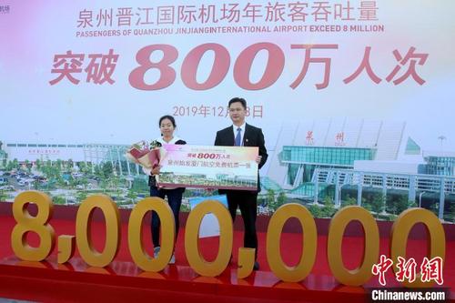 中国侨网12月13日，旅客黄小姐（左）幸运地成为泉州晋江国际机场2019年的第800万名乘客。　叶扬　摄