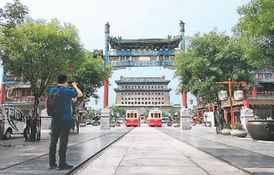 中国侨网游客在北京前门大街拍照留念。