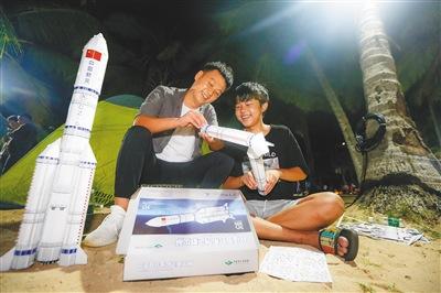 中国侨网等待火箭发射的两兄弟一起拼火箭模型。本报记者 袁琛 摄