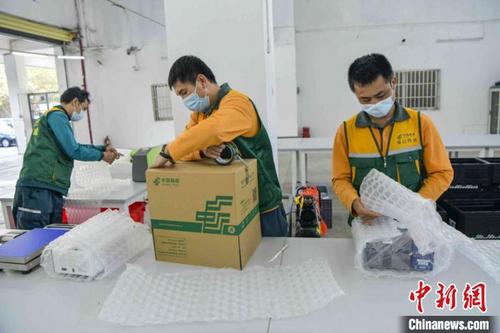中国侨网邮政工作人员打包离岛免税品。　骆云飞　摄