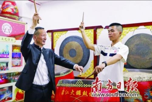 中国侨网吴顺喜（左）手把手指导年轻学员掌握潮州大锣鼓技艺。张伟炜 摄