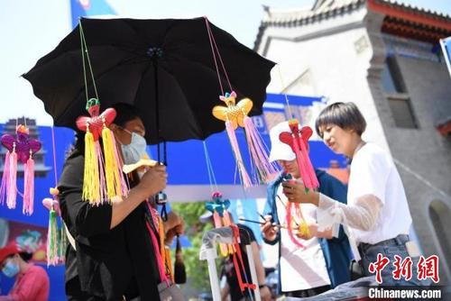 中国侨网端午节期间,甘肃“非遗+民俗”游受追捧。图为在假日期间举行的非遗节会上,游客挑选手工香包。杨艳敏 摄