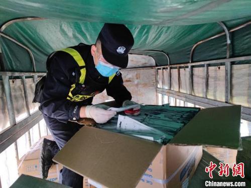 中国侨网执勤民警按要求上车开箱检查货物。　韦著鹏　摄