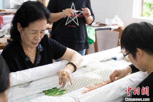 中国侨网康惠芳(左一)绣制新作品中的广济楼。 陈楚红 摄