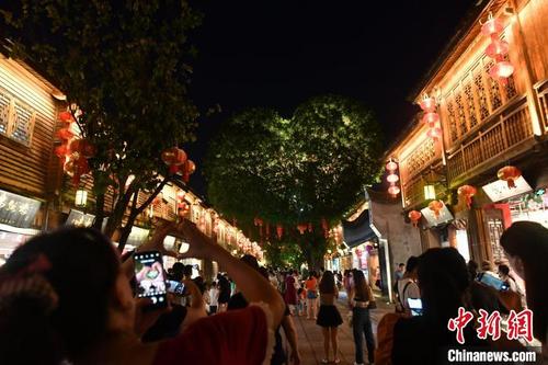 中国侨网图为游客与“爱心树”合影。 吕明 摄