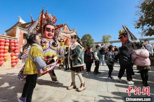 中国侨网“电音三太子”演员与小朋友互动玩耍。　赖进财　摄