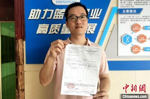 中国侨网企业人员展示自助打印的首份输菲律宾RCEP原产地证书。　王明乙　摄