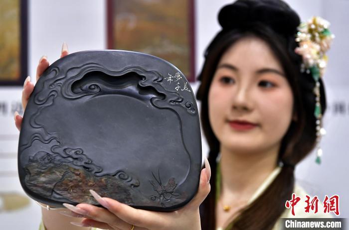 中国侨网图为工作人员展示恢复生产的凤咮砚新品。 中新网记者 张斌 摄