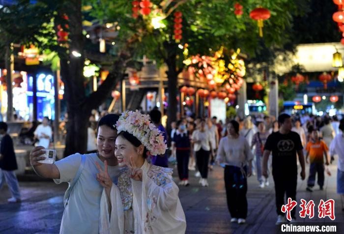中国侨网7月9日，市民、游客在福州三坊七巷游览。连日来，福州持续高温天气，许多市民“昼伏夜出”以避酷暑，同时也让福州的“夜经济”不断升温。中新社记者 吕明 摄