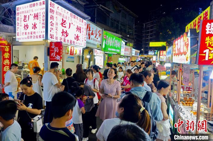 中国侨网7月12日晚,福建福州,许多市民和游客在仓山区夜市购买美食。近日,福州持续高温,市区许多夜市日渐火爆。中新社记者 王东明 摄