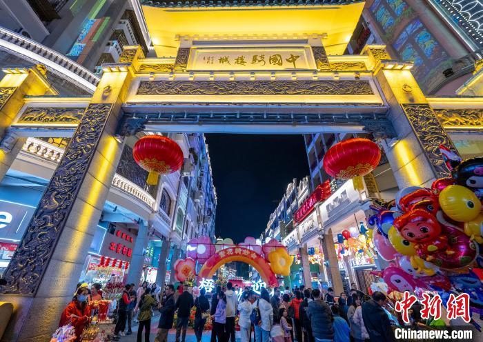 中国侨网春节前夕,广西梧州市万秀区骑楼城新春集市迎来许多民众,民众在带孩子逛街游玩的过程中置办年货、品当地美食。
