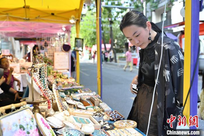 中国侨网5月15日,第十二届广州市侨文化活动日在华侨新村举行。本届侨文化活动日以“侨爱祖国,祖国爱侨”为主题,结合广州华侨新村奠基70周年系列活动,将先后举办侨文化专题巡回展、侨界青年足球交流赛、华侨新村名人旧居探访等活动,向市民游客展示广州侨界风采。图为市民在华侨文化市集上游玩。中新社记者 陈骥旻 摄