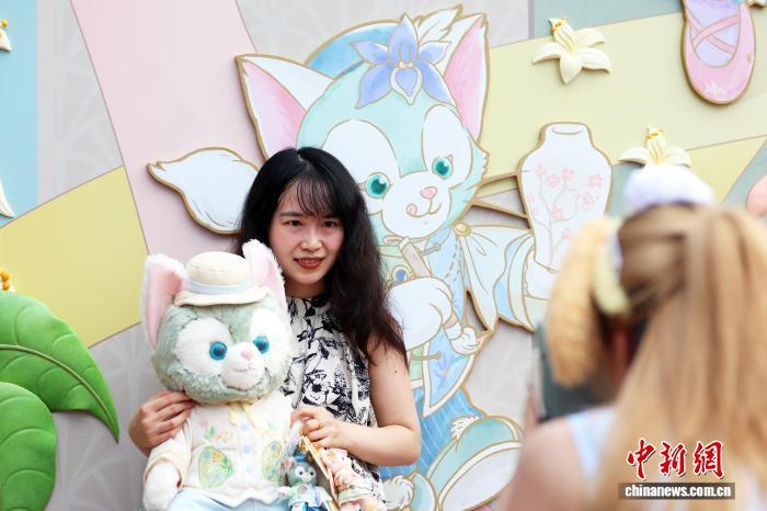 中国侨网9月7日，游客在互动墙前拍照留念。当日，正在上海迪士尼乐园举行的萌聚达菲月备受粉丝青睐，其间推出的一系列趣味十足的新“花”样，吸引着各地游客前来共享欢乐时光。中新社记者 汤彦俊 摄