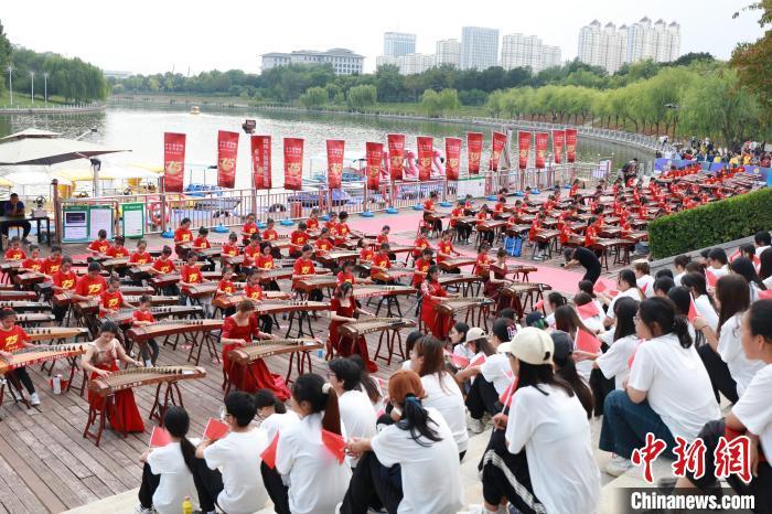 中国侨网国庆节临近，河北省衡水市滏阳河畔一文化广场，260名古筝艺人正在共同弹奏乐曲。《万疆》《沧海一声笑》《男儿当自强》等多首流行歌曲曲目在古筝艺人的指下行云流水，时而激昂紧凑，时而舒缓悠扬，别有一番韵味。古筝演奏的同时，140名模特身着各式旗袍走秀。衡水市桃城区举办的此次活动以“古风韵桃城 国乐贺盛世”为主题，旨在丰富广大群众文化生活，以“筝”为媒，展现中华传统乐器的魅力。图为古筝弹奏现场。尚长治 摄