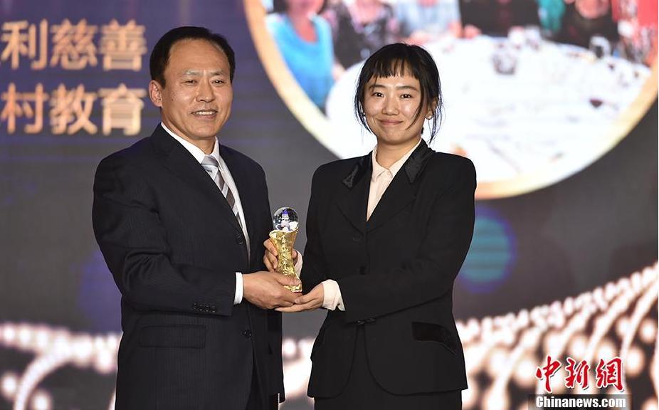 中国华文教育基金会秘书长于晓（左）为欣欣教育基金会义工团队颁奖