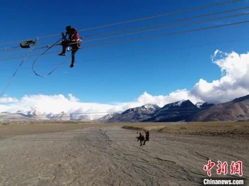 中国侨网图为6月23日，西藏阿里联网工程施工人员在日喀则希夏邦马峰附近进行走线作业，安装绝缘设备。　江飞波 摄
