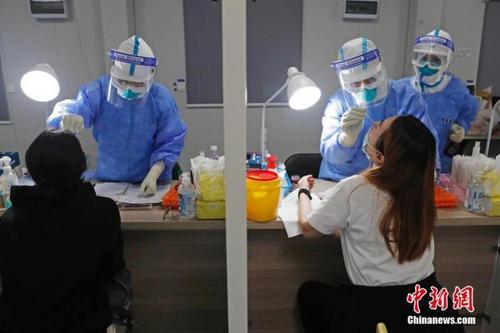中国侨网资料图：机场工作人员对入境旅客进行核酸检测。中新社记者 殷立勤 摄