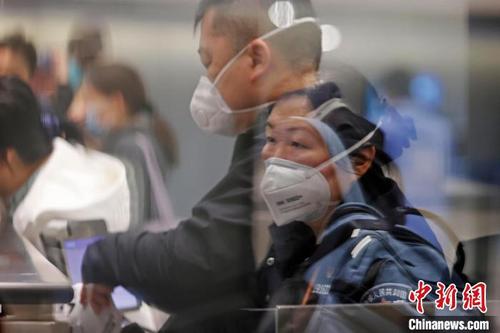 中国侨网虹桥边检站民警在对出境旅客进行信息核查。　殷立勤　摄