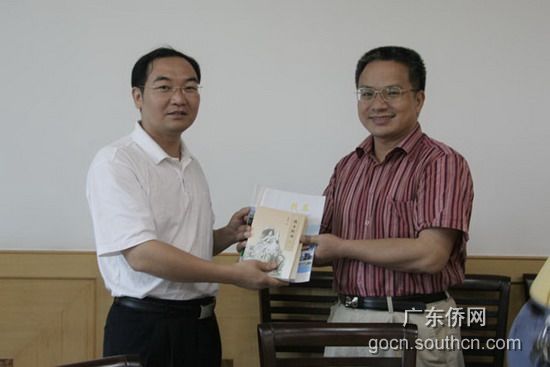 陈煌副局长(左)向贺胜文副校长赠送有关资料
