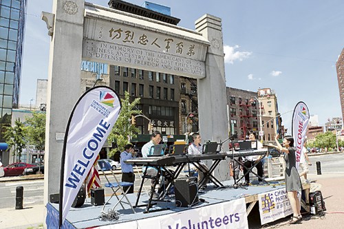 华英学院成人班的演出者在且林士果牌坊下演奏.(美国《侨报》/苏夏竹