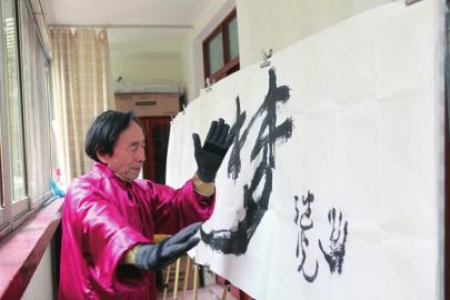 中国侨网何继光在进行练习太极指掌拳书.(彭戎 摄)