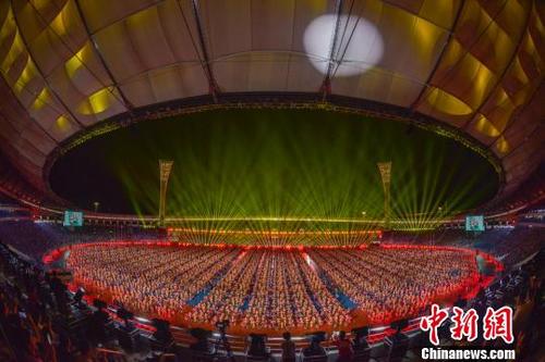 中国侨网万人献礼海南建省办经济特区30周年,同跳竹竿舞破世界纪录。 骆云飞 摄