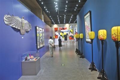 中国侨网昨日（7月16日），首创非遗设计创新展在咏园内举办。图为观众正在室内参观非遗工艺品。