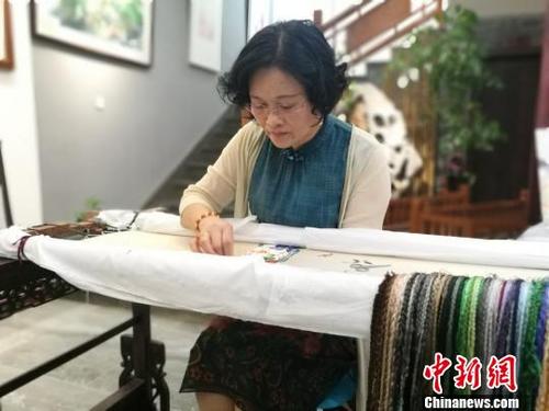 中国侨网姚琴华正在完成一件新的刺绣作品。　钟升　摄