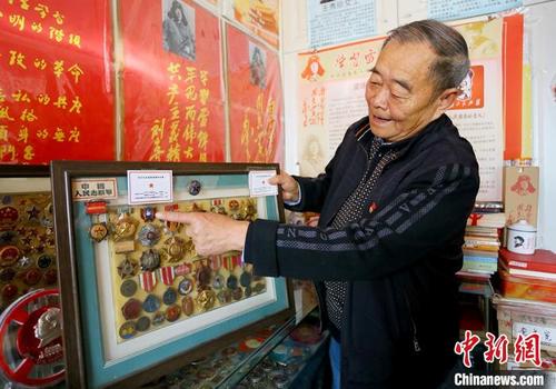 中国侨网    甘肃兰州81岁的苏留曾老人历时五十余年收集红色藏品二十余万件。图为苏老介绍其收藏的功勋章。　高展　摄