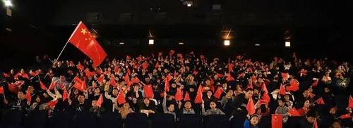中国侨网电影放映前，观众挥舞手中的红旗合影留念。(《欧洲时报》/林碧燕 摄)