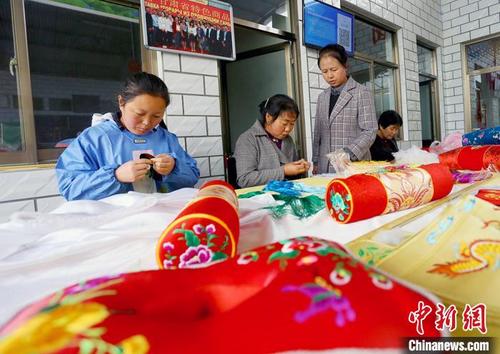 中国侨网庆阳淑方香包刺绣有限公司的绣娘正在制作香囊。　高展　摄