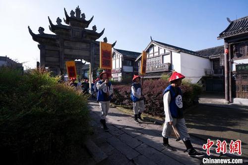 中国侨网参加情景再现演出的演员从南关石牌坊穿过。　多帕斯·乔治　摄