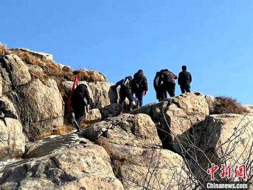 中国侨网图为调查人员奔波在陡山峭壁之间,探寻调查文物点。山东省石窟寺专项调查工作协调推进小组供图
