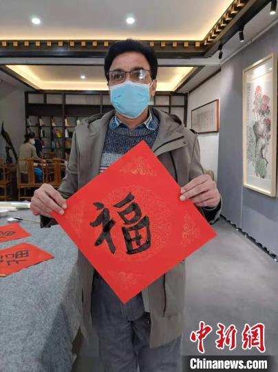 中国侨网扎法展示自己亲手写的“福”字。受访者供图