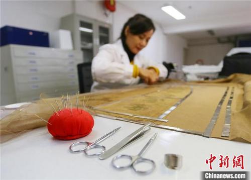 中国侨网4月下旬，赵喜梅正在修复南北朝时期纺织品文物。　高展 摄