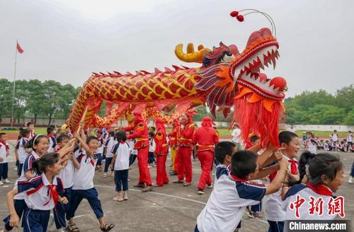 中国侨网6月11日,江西省新余市仙女湖区观巢学校的小学生在“非遗进校园”主题活动中体验舞龙。 赵春亮 摄