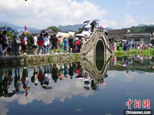 中国侨网宏村景区水清天蓝、绿荷盈湖,八方游客纷至沓来。 吴寿宜 摄
