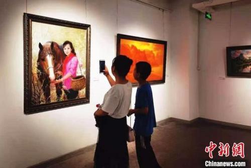 中国侨网图为7月27日，“惟美无界—当代朝鲜油画名家精品展”正在兰州展出，吸引民众驻足欣赏。　史静静 摄
