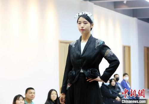 中国侨网9月26日，甘肃东乡秀娘身着带有“东乡刺绣”元素的民族服饰T台走秀。　高展　摄