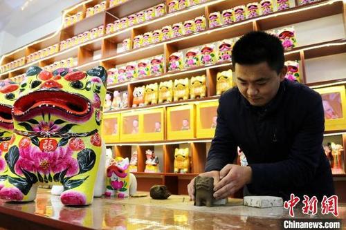 中国侨网为迎接虎年的到来,聂鹏提前策划了虎年主题泥塑。图为聂鹏展示泥塑制作过程。 沙见龙 摄